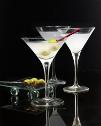 Cocktail in martini glasses with olives on black background